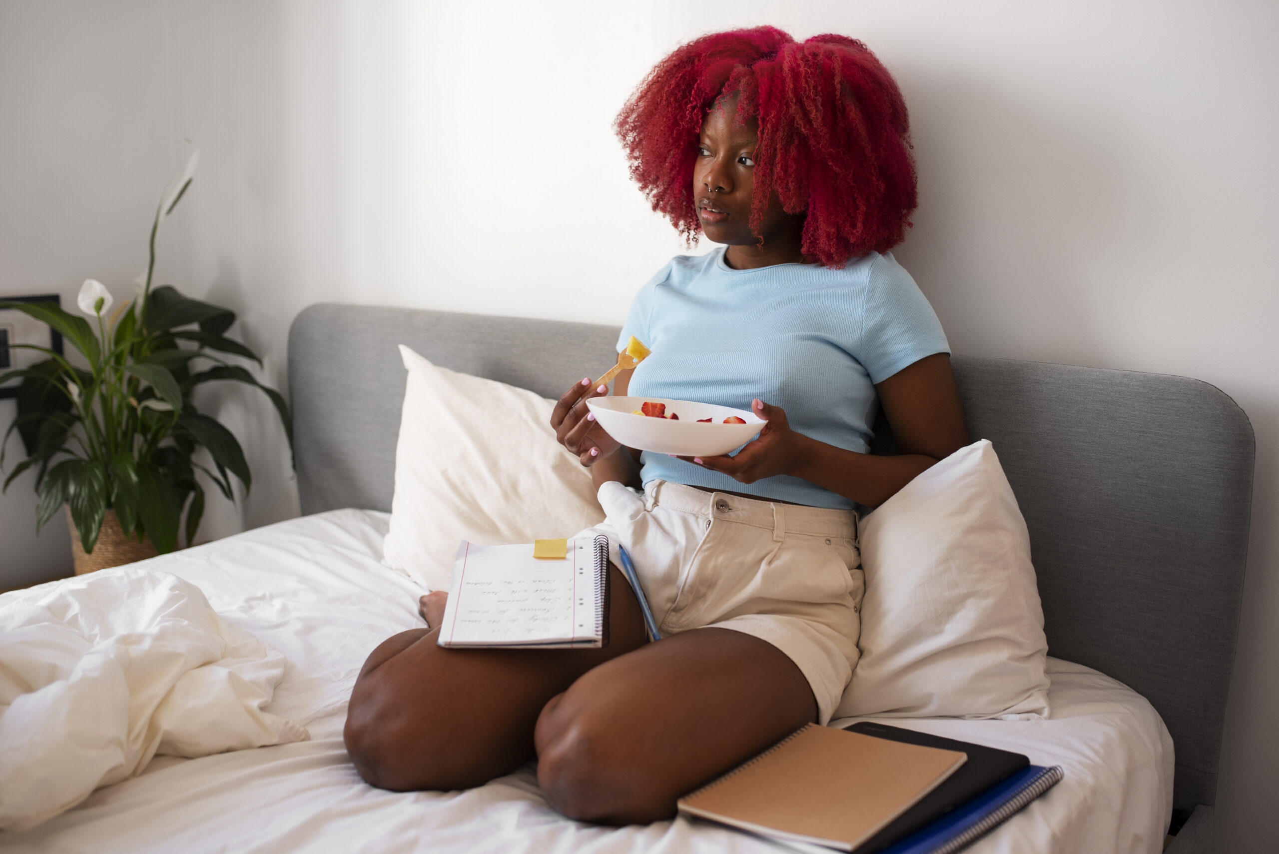 A-student-sitting-by-a-window-with-soft-lighting-reflecting-on-life-and-dreaming-of-a-peaceful-home.