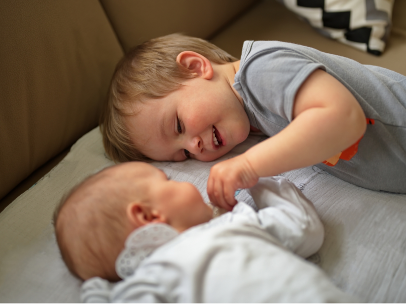 toddler-bonding-with new-sibling-positive-connection-moment