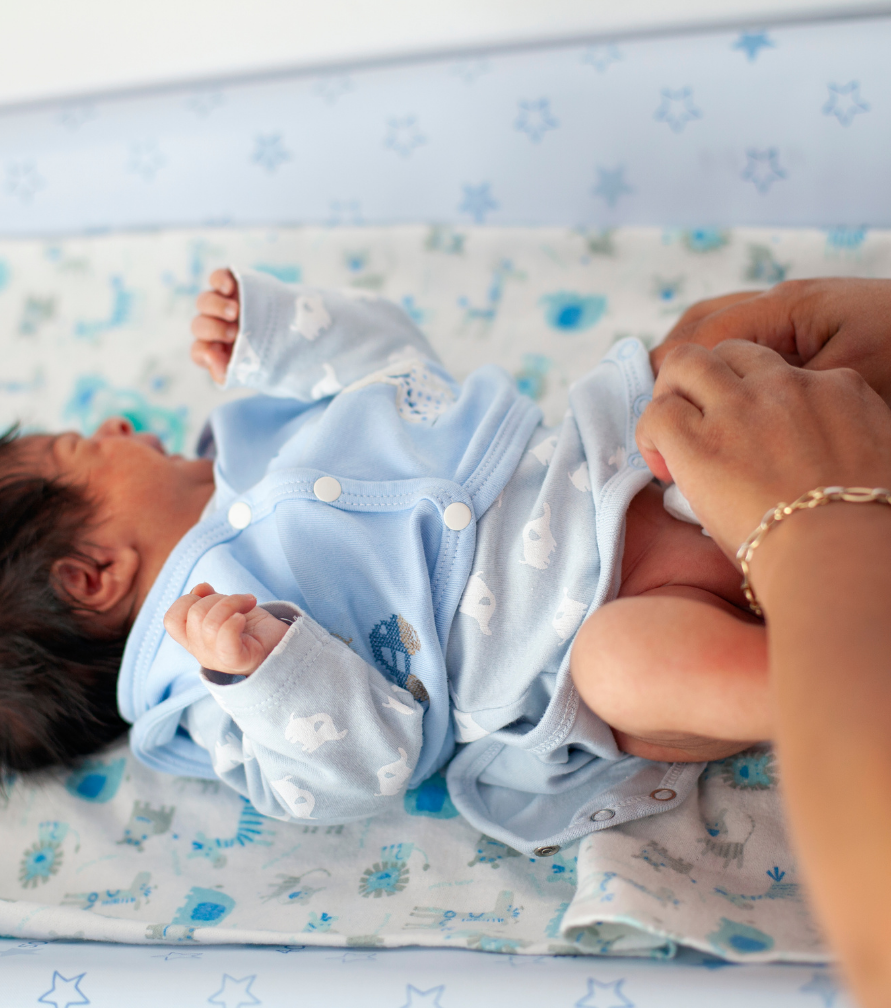 Mom holding baby while moving gently around the room, relaxed routine lifestyle shot.